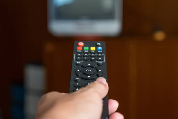 istock Remote TV in hand on background blurred 1034221720