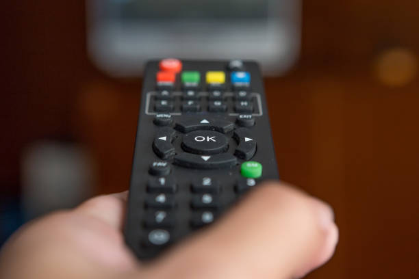 istock Remote TV in hand on background blurred 1034221764