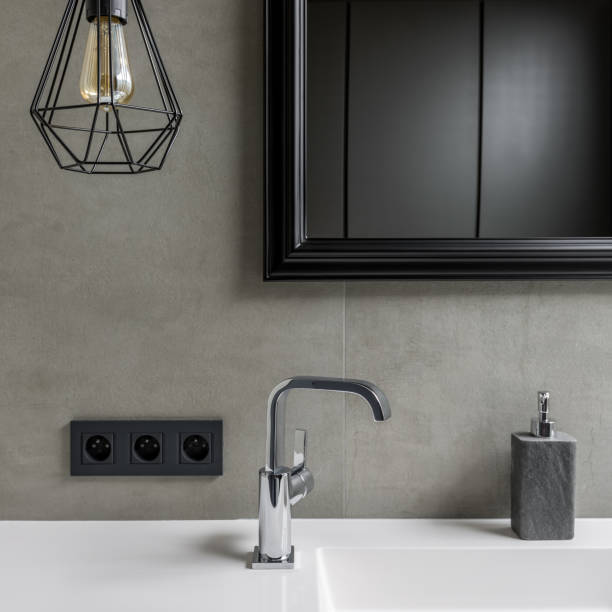 Gray bathroom with black mirror stock photo