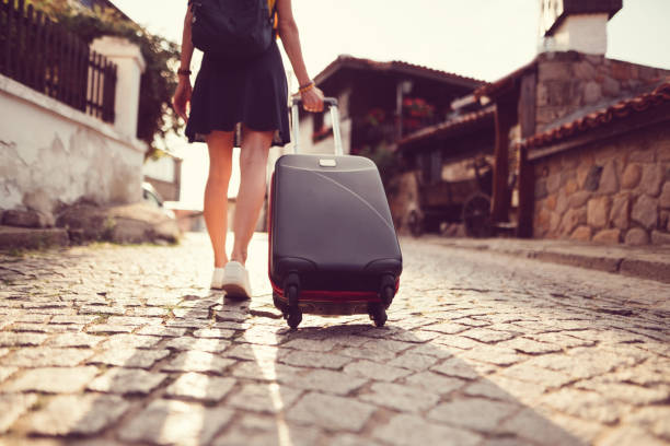 Tourist woman traveling around Europe Rear view of woman just arrived at travel destination and pulling a suitcase dragging photos stock pictures, royalty-free photos & images