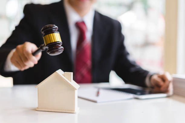 auctioneer knocking down a model house with his gavel, property sale auction concept - bidder imagens e fotografias de stock