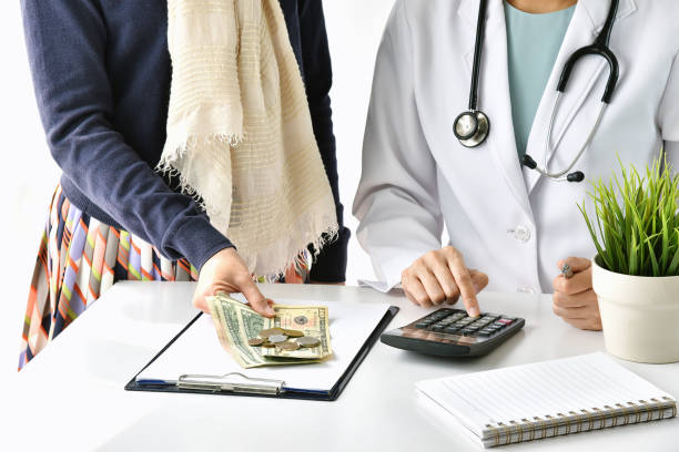 spese ospedaliere e mediche, medico e paziente donna calcolano le spese di tassa di trattamento della malattia, concetto di assicurazione sanitaria. - currency stethoscope healthcare and medicine savings foto e immagini stock