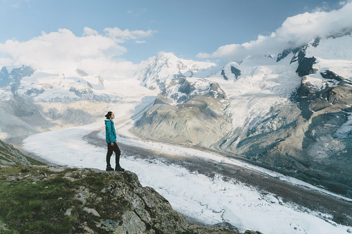 Young Caucasian woman looking at the scenic view of  the glacier in Swiss alps in Gornergrat