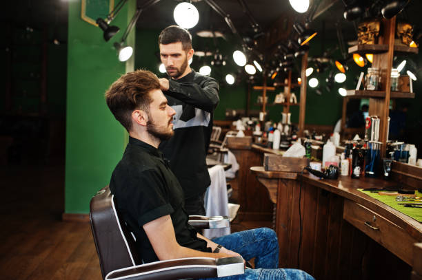 istock Handsome bearded man at the barbershop, barber at work. 1034239770