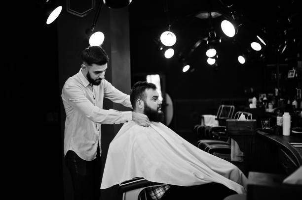 istock Handsome bearded man at the barbershop, barber at work. 1034239914