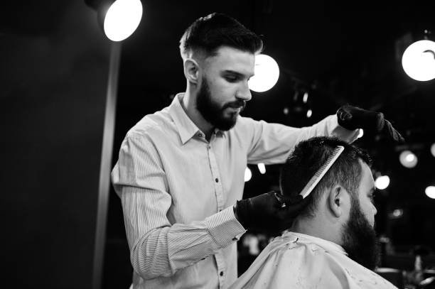 istock Handsome bearded man at the barbershop, barber at work. 1034244376