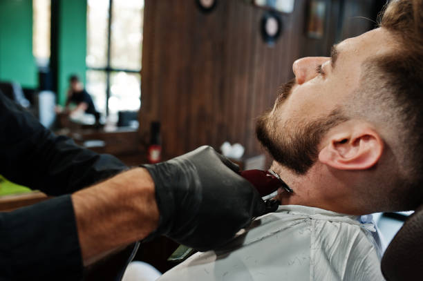 istock Handsome bearded man at the barbershop, barber at work. 1034244378
