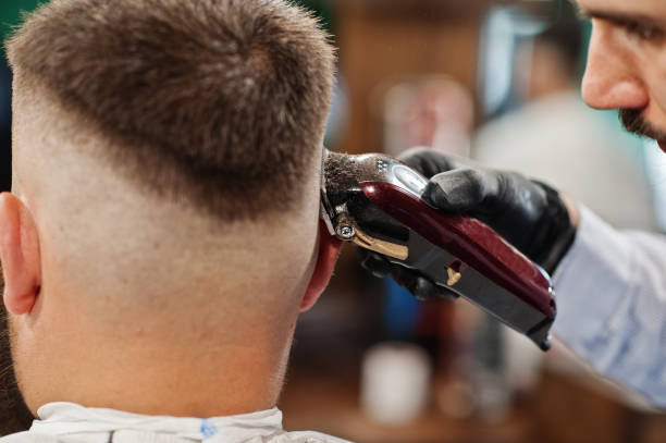 istock Handsome bearded man at the barbershop, barber at work. 1034244522