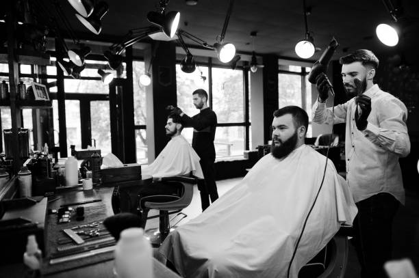 istock Handsome bearded man at the barbershop, barber at work. 1034244560