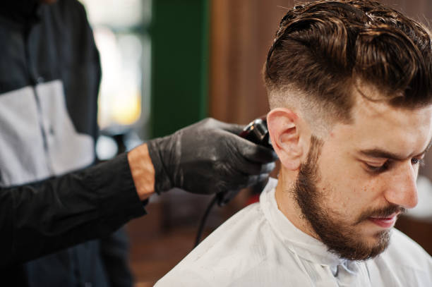 istock Handsome bearded man at the barbershop, barber at work. 1034244672