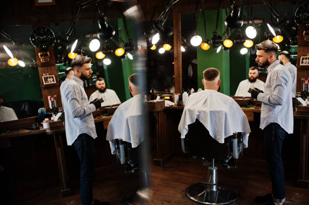 istock Handsome bearded man at the barbershop, barber at work. 1034245388