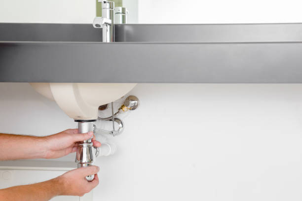 istock Man's hand checking new metal siphon under the sink. 1034245436