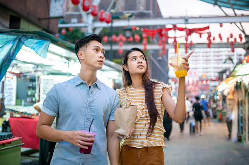 Asian love couple having fun in Kuala Lumpur's Chinatown.