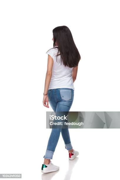 Rear View Of Casual Woman Walking And Looking To Side Stock Photo - Download Image Now