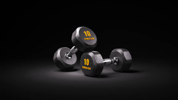 Two black rubber dumbbells on dark