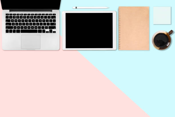 istock Flat lay photo of office table with laptop computer, digital tablet, mobile phone and accessories. on modern two tone (blue and pink) background. Desktop office mockup concept. 1034250164