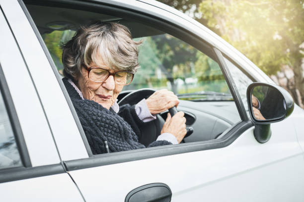 istock Senior woman driver turns to reverse, grimacing 1034252848