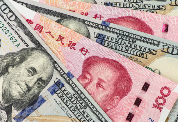 istock US dollar bill and Chinese yuan banknote. USD vs RMB. 1034253924