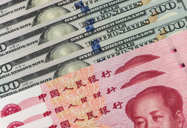 istock US dollar bill and Chinese yuan banknote. USD vs RMB. 1034253996