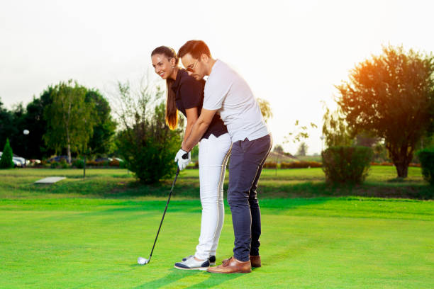 istock Male instructor showing woman to play golf 1034256544