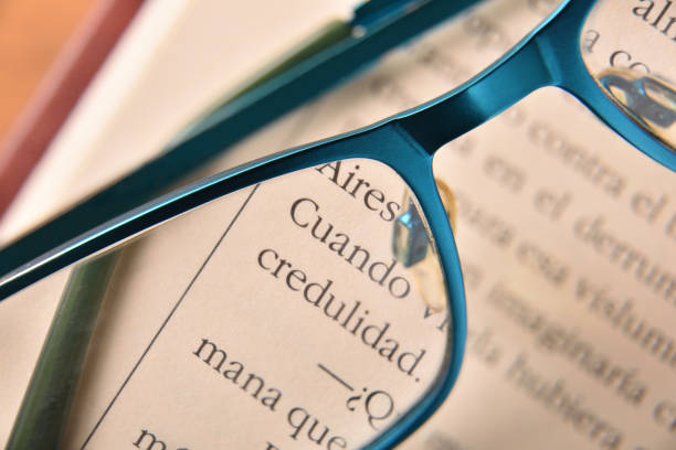 Detail of blue reading glasses on open book close up.Concept need glasses to read. Top view. Horizontal composition