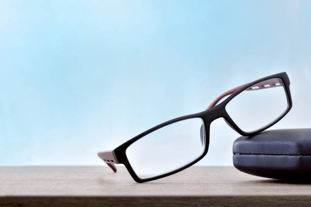 istock Eyeglasses with case on wood table blue background 1034257024