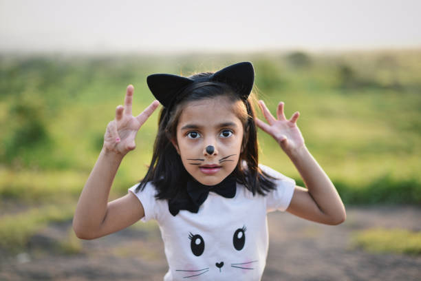 A joyful moment of a child holding a black-and-white pet cat in a lush green garden, highlighting companionship, tenderness, and the happiness of interacting with beloved pets in nature.