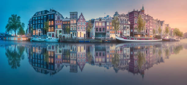 Amstel river, canals and sunrise over beautiful Amsterdam city. Netherlands.