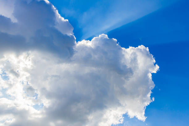 istock Blue sky with clouds and sun reflection in water in the clouds 1034269948