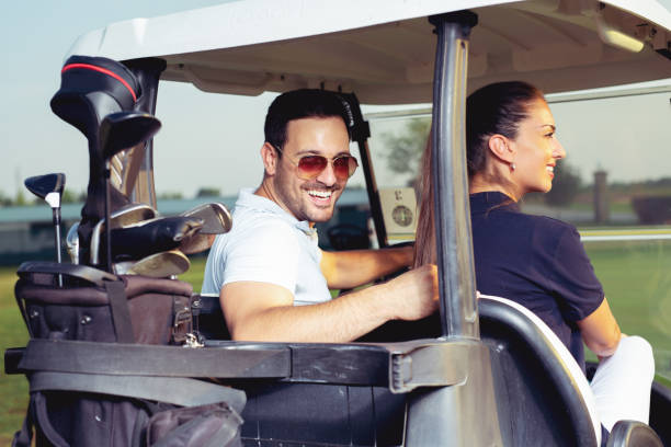 istock Golfing couple in golf cart smiling 1034269976