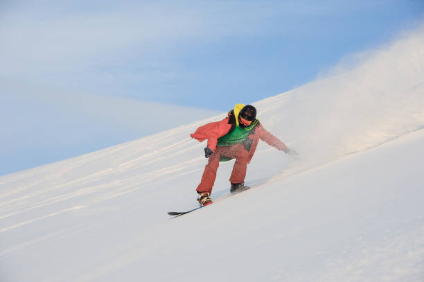 istock Active snowboarder riding on the snowy slope 1034270028