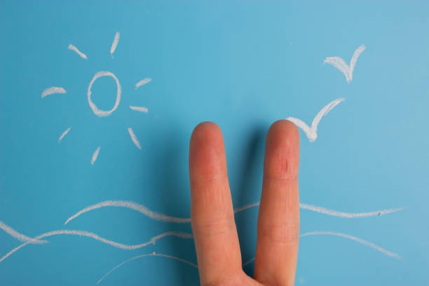 istock vacation concept image. two fingers on the sea and sun background 1034275762
