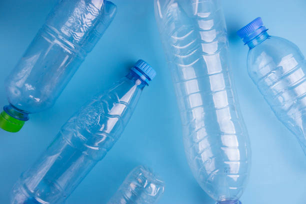 istock Group plastic bottles of water on blue background 1034275856