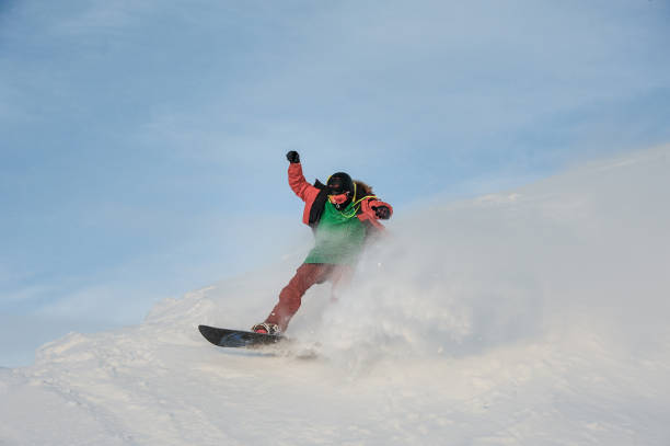 istock Young man having fun sliding on the snowboard 1034275956