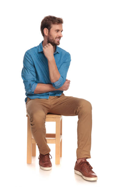 istock pensive young casual man looks to side while sitting 1034276048