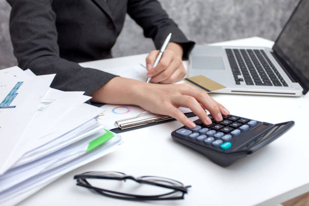 istock Business women using calculator at working with financial reports 1034276232