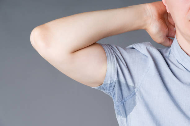 灰色の背景に汗まみれの脇の下を持つ男 - sweat armpit sweat stain shirt ストックフォトと画像