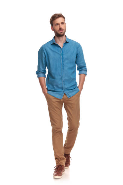 istock young casual man walking with hands in pockets 1034283254