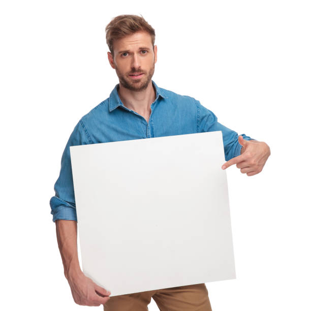 istock young casual man pointing finger at a blank board 1034283386