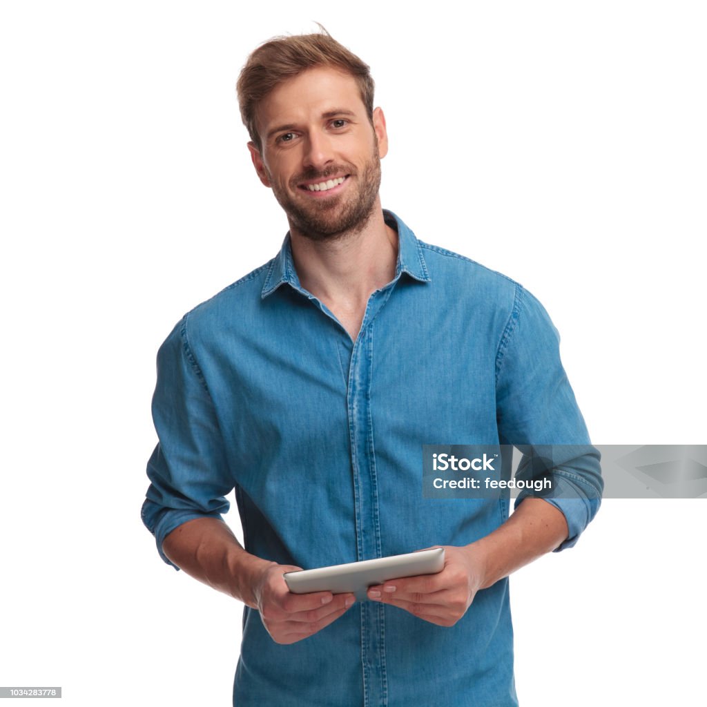 smiling young casual man holding a tablet smiling young casual man holding a tablet pad computer on white background Men Stock Photo
