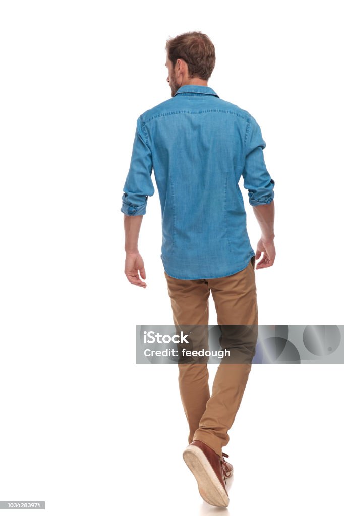 back view of  casual man walking and looking to side back view of a casual young man walking and looking to side on white background Rear View Stock Photo