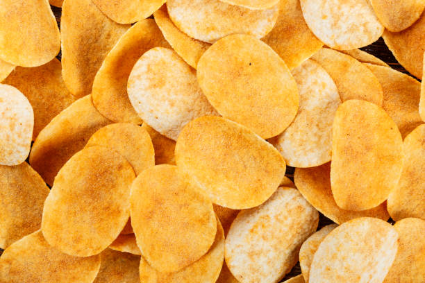 istock potato chips are scattered as a background. 1034284254