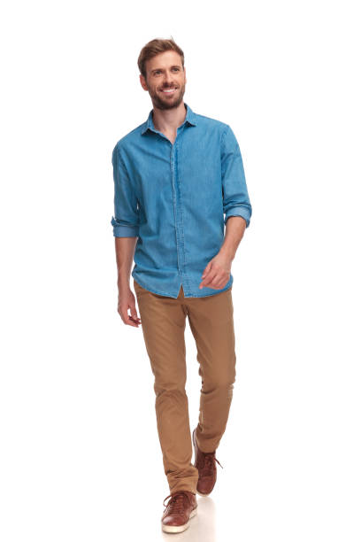 istock smiling young casual man walking and looking to side 1034284624