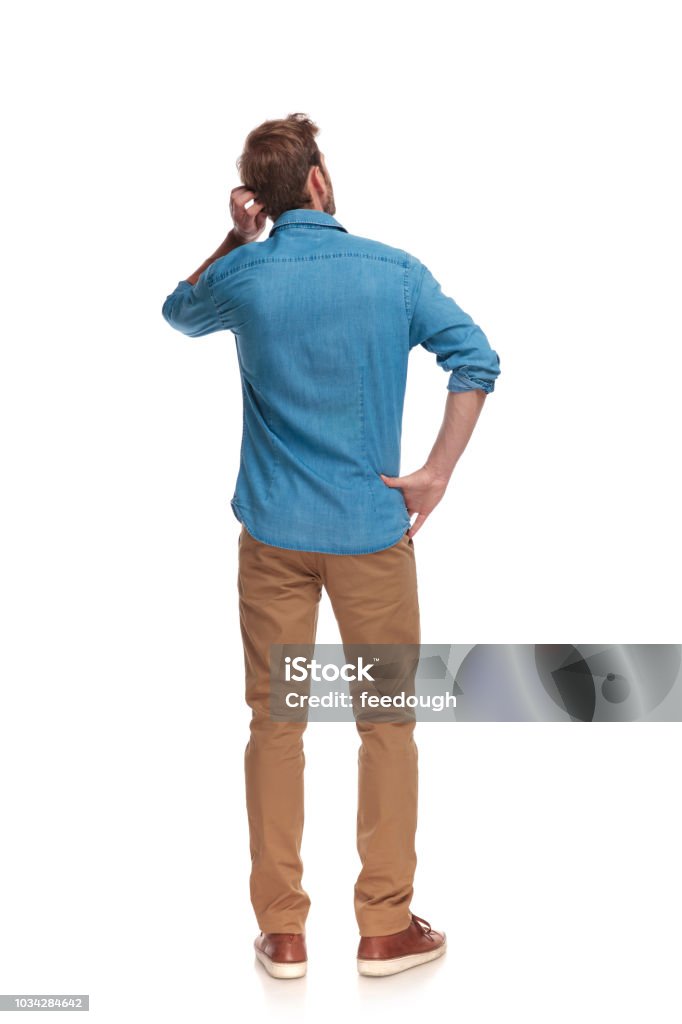 back view of a young casual man scratching his head back view of a young casual man scratching his head on white background Men Stock Photo
