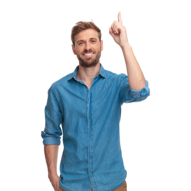 istock smiling casual man with one hand in pocket points up 1034286752