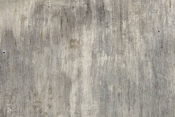 Close-up of a dilapidated plywood sheet with cracks and scratches. Close-up surface of an aged sheet of plywood, scratched and cracked, texture for background. plywood stock pictures, royalty-free photos & images