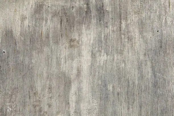 Photo of Close-up of a dilapidated plywood sheet with cracks and scratches.