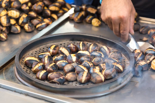 a street salesman sells freshly roasted chestnuts in istanbul, turkey. turkish cuisine - chestnut food nut fruit imagens e fotografias de stock