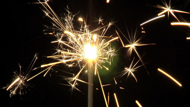One sparkler in darkness with lens flare