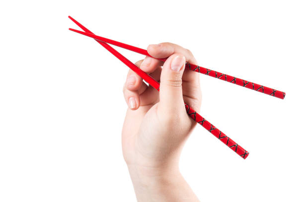 istock Hand with red chopsticks isolated on a white background 1034294014